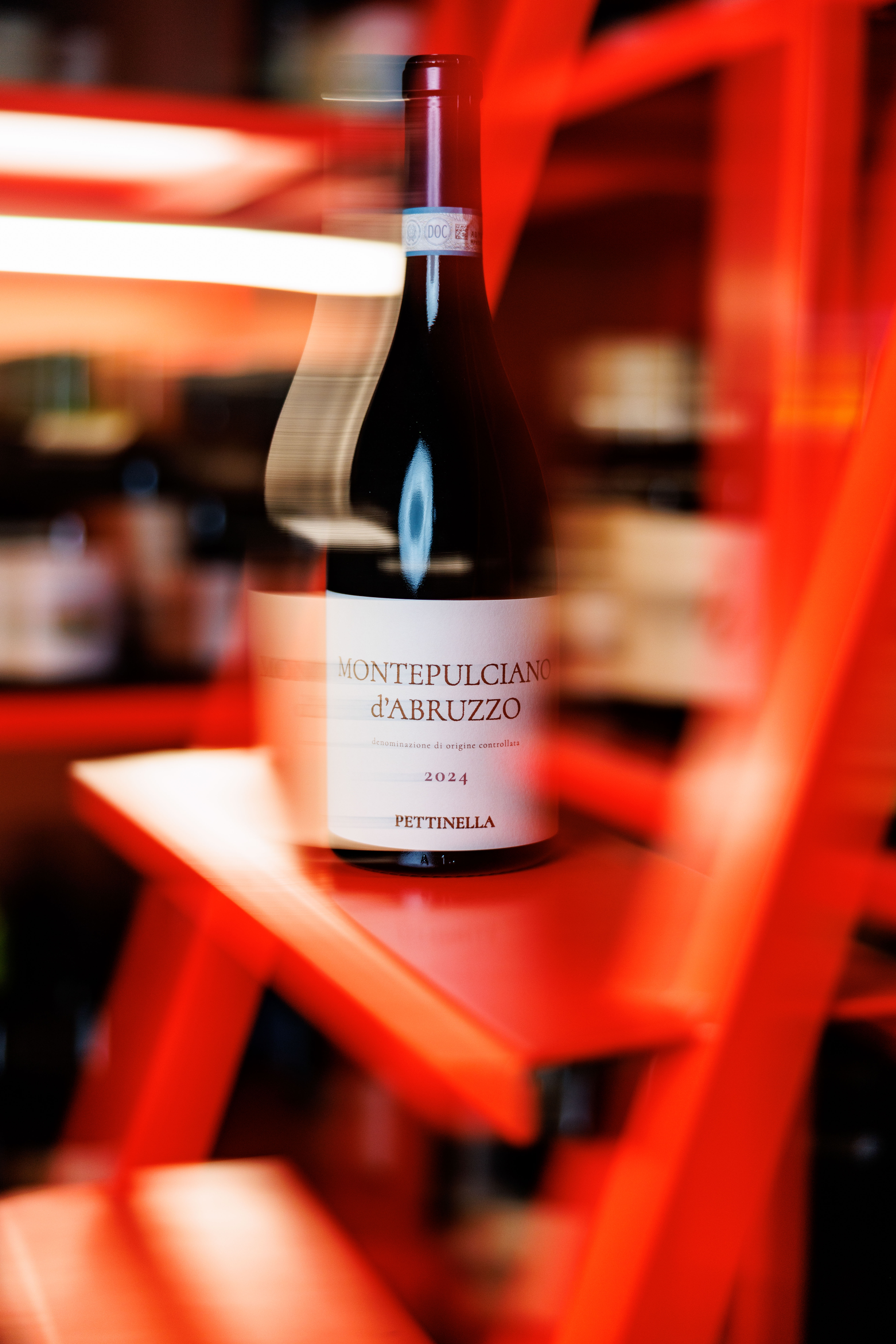 Bottle of Montepulciano d'Abruzzo red wine on a shelf under red lighting