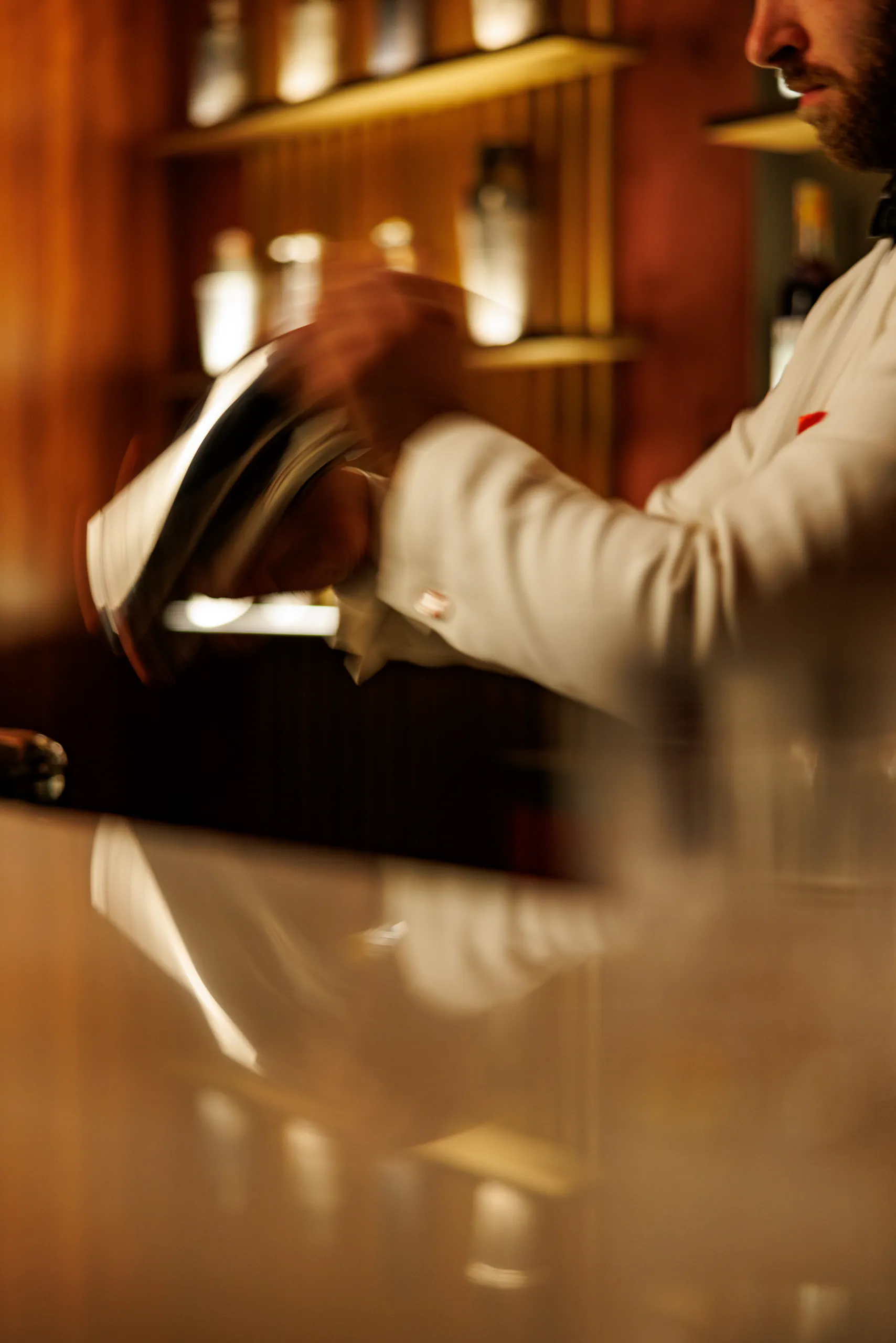 Bartender at work behind a bar in a warm backlit atmosphere — Camparino in Galleria, Milan