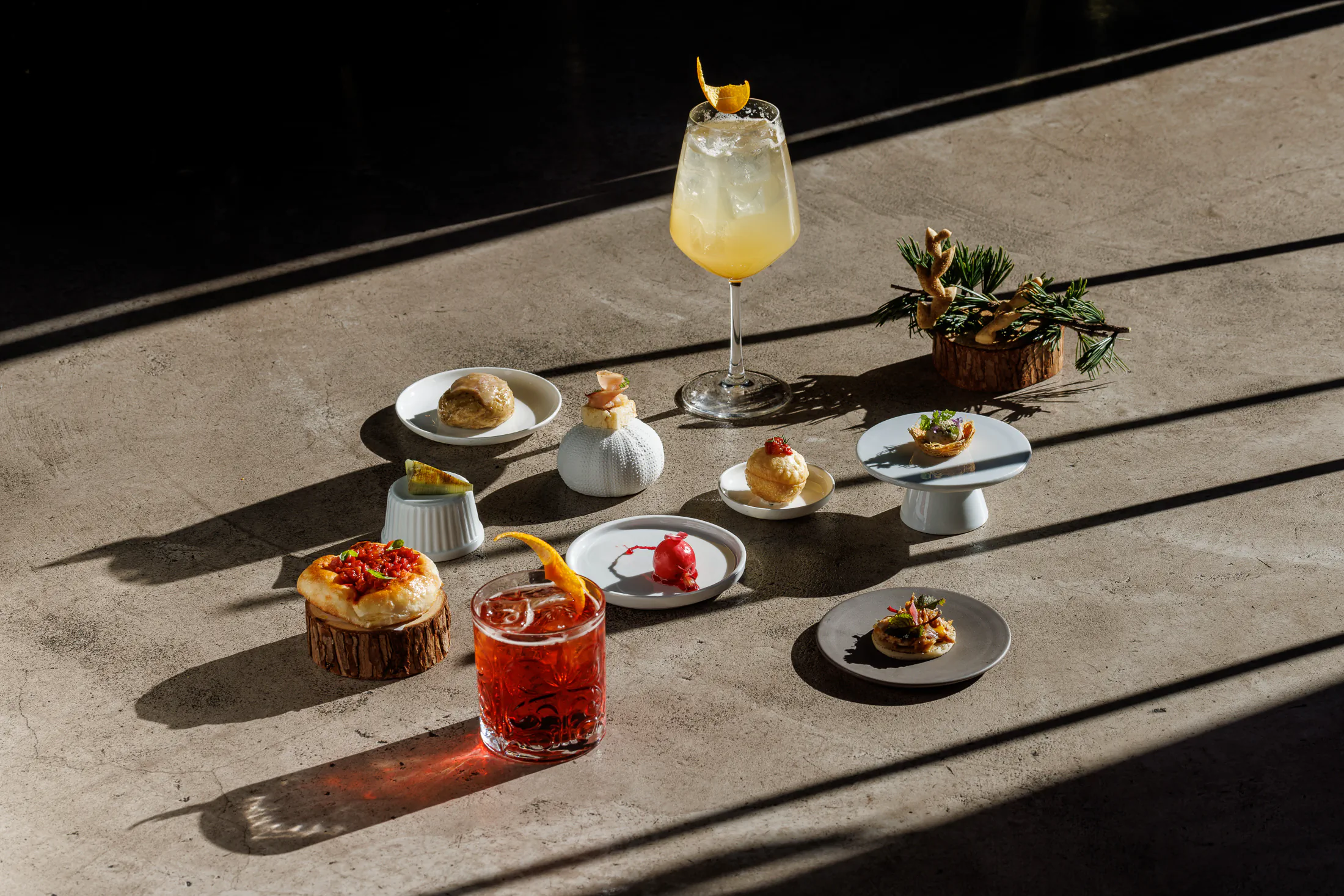 Aperitivo spread of cocktails and small bites in warm sunlight