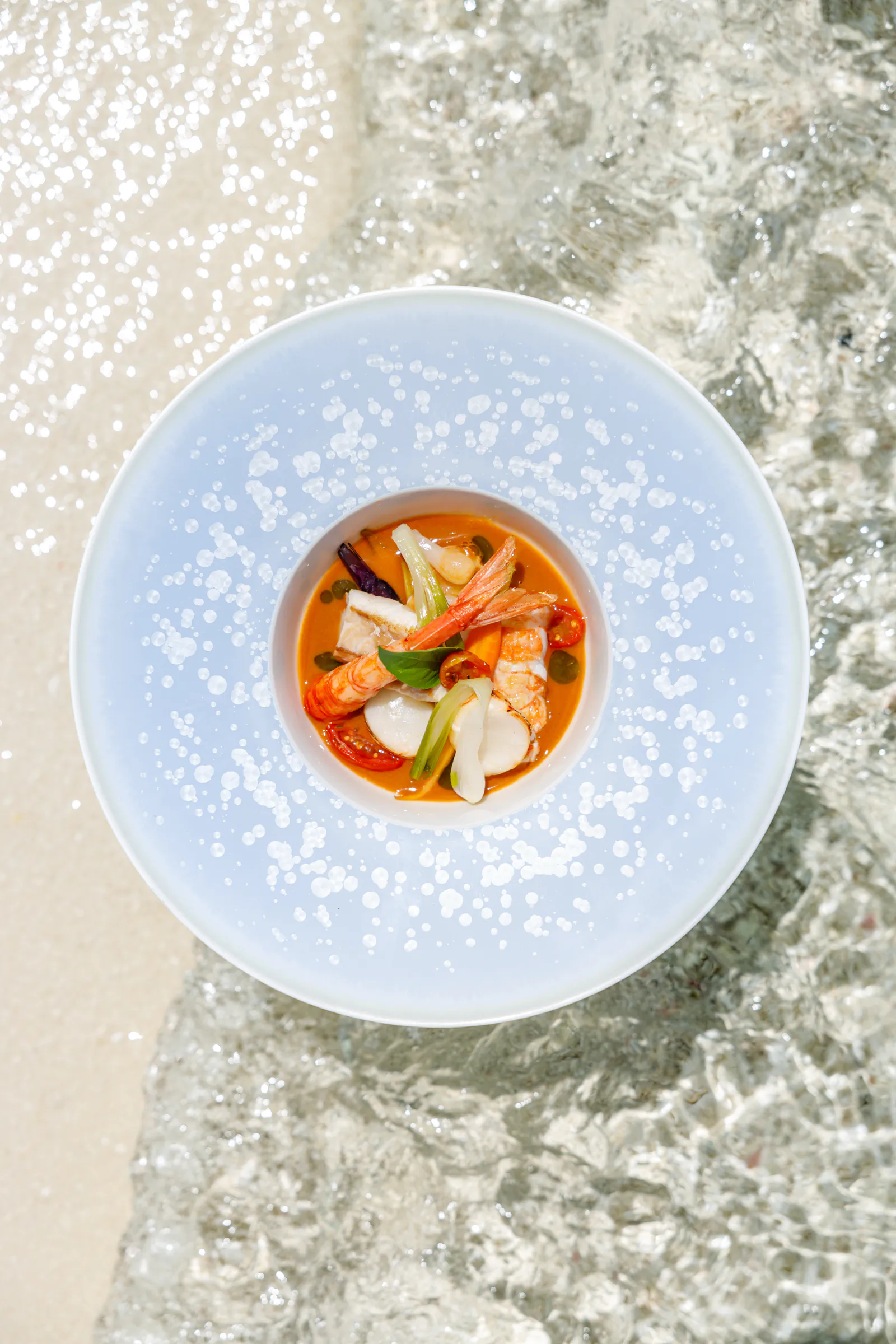 Seafood soup in a white bowl, seen from above - Four Seasons Maldives