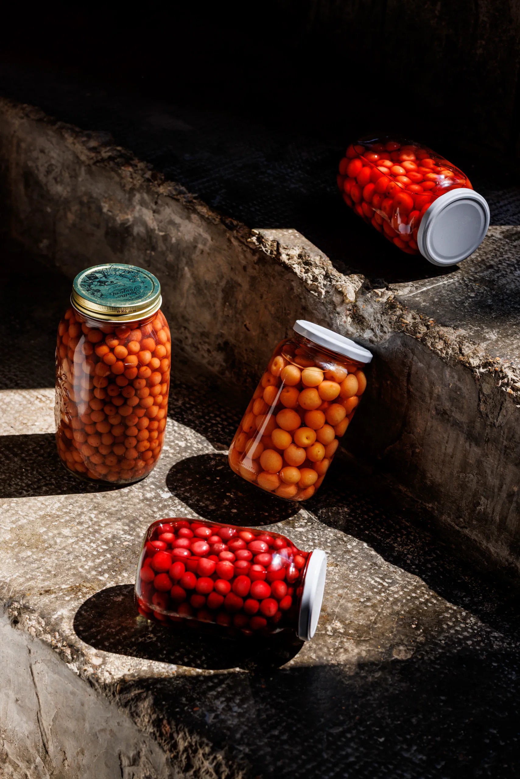 Jars of preserved cherry tomatoes on stone steps - UNE, Capodacqua, Italy