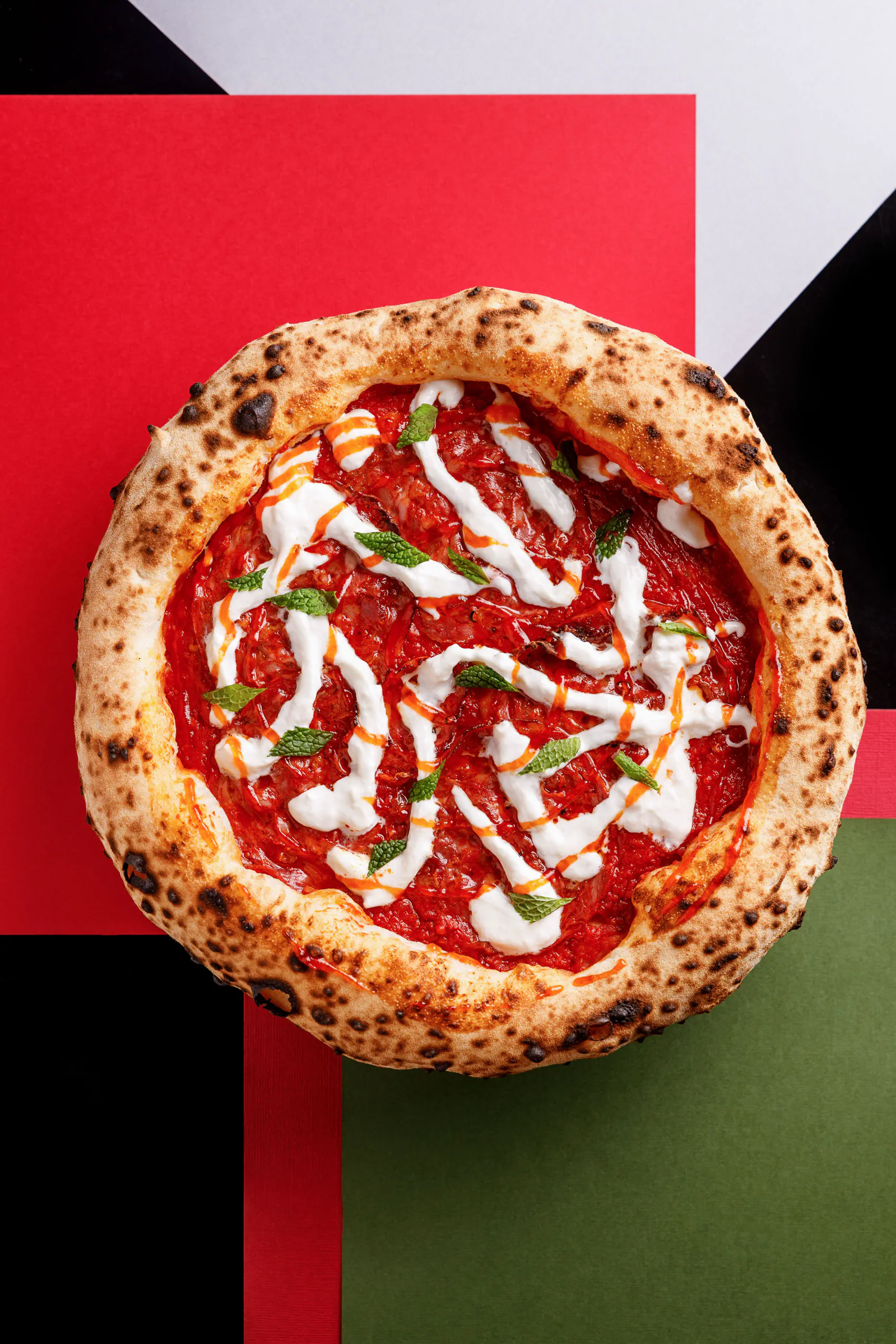 Salami pizza with mozzarella on a graphic red-and-green background - SEU Pizza, Rome, Italy
