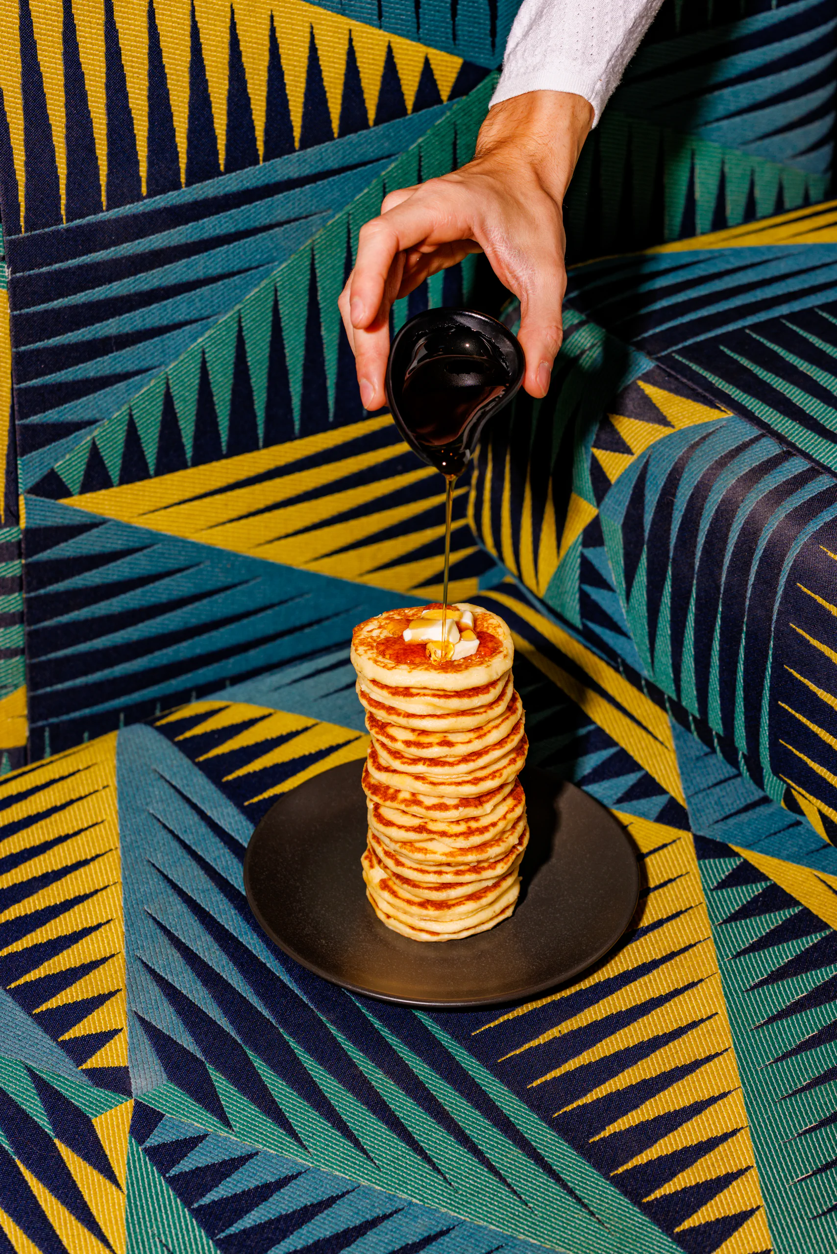 Stack of pancakes with syrup poured over on a graphic background - Straf, Milan, Italy