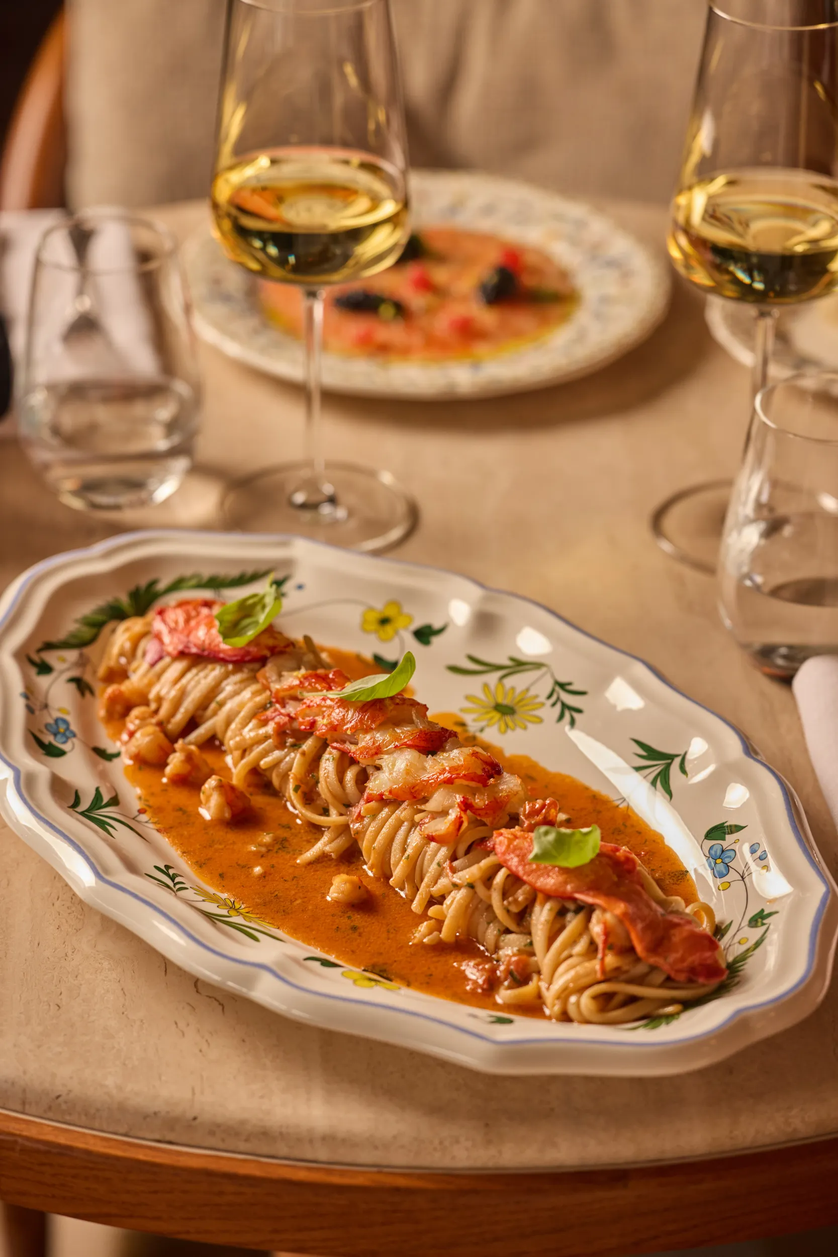 Lobster linguine on a decorative platter with white wine - Gigi Rigolatto, La Minerva Orient Express, Rome, Italy