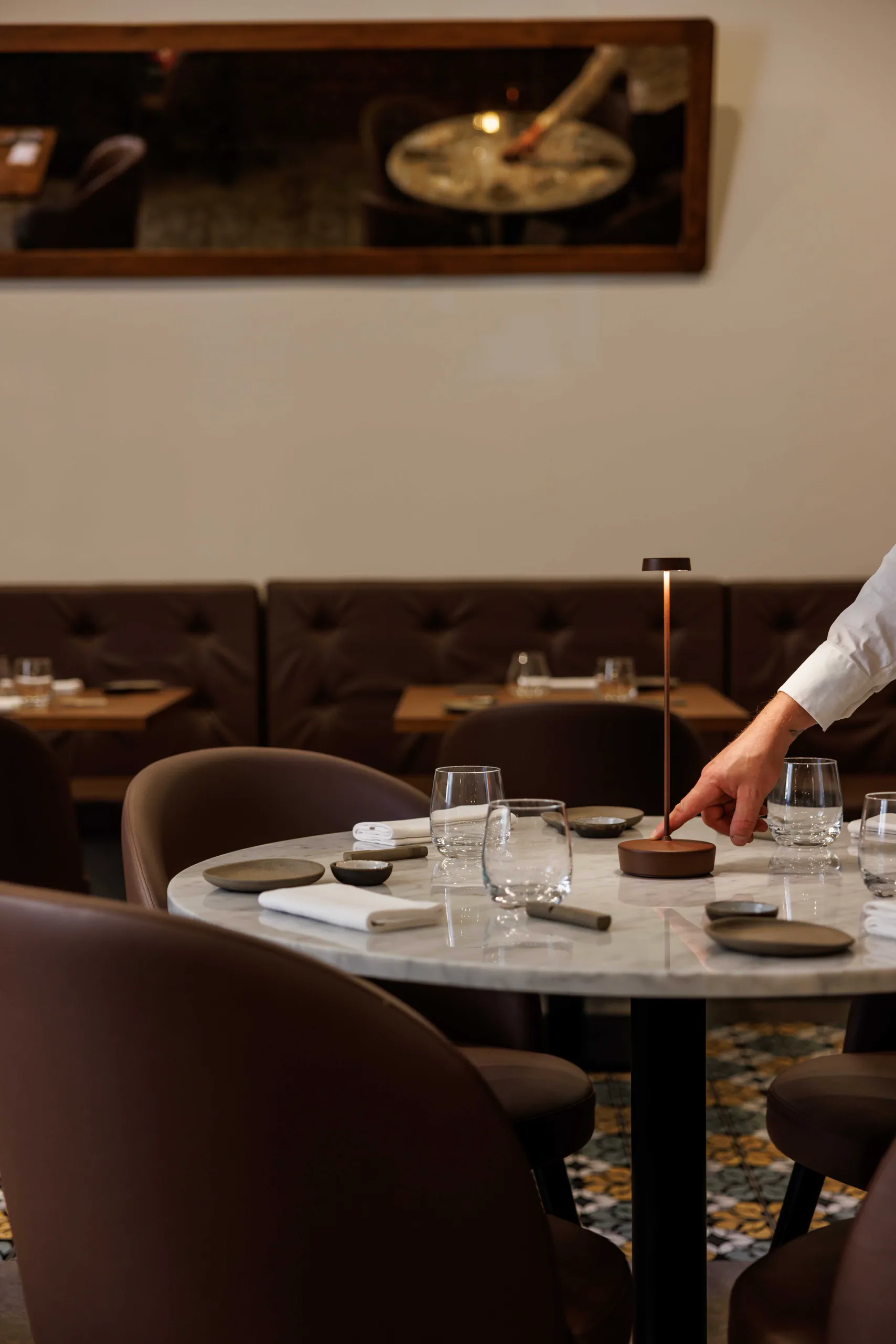 Waiter setting a restaurant table with glassware